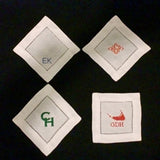 Set of 4 cocktail napkins with monogram examples (left to right): Baby Blue Arial Large Initials All Caps, Orange Diamond Monogram, Kelly Copperplate Initials, Red Island w/ Bookman Initials.