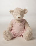 Teddy bear with pink striped overalls.