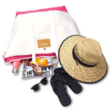 Neon pink jumbo tote with gold stamped monogram holding magazines, sunscreen, water bottle, sunglasses, flip flops and hat