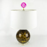 Hot pink block monogram lamp finial with brass base shown on top of a lamp