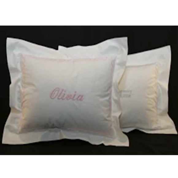 Two chain stitch pillows. Pillow in front has commercial script font with pink thread that matches the chain stitch. Pillow in back has bookman upper and lowercase font in blue thread that matches the chain stitch.