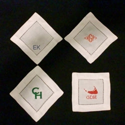Set of 4 cocktail napkins with monogram examples (left to right): Baby Blue Arial Large Initials All Caps, Orange Diamond Monogram, Kelly Copperplate Initials, Red Island w/ Bookman Initials. 